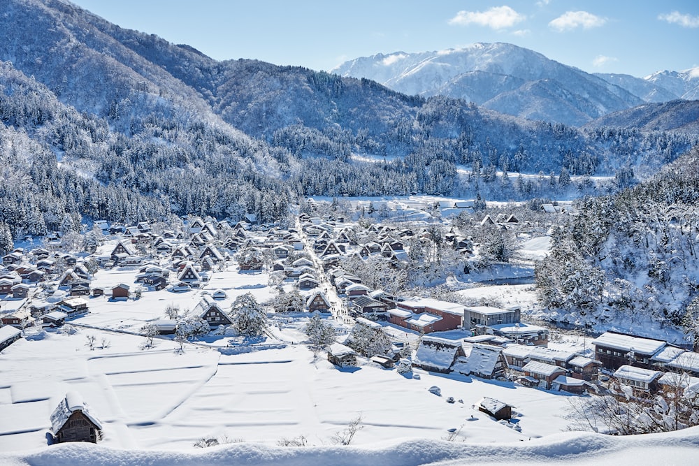 a snow covered village surrounded by mountains and trees