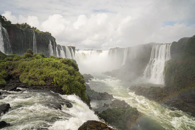 a large waterfall with a rainbow in the middle of it