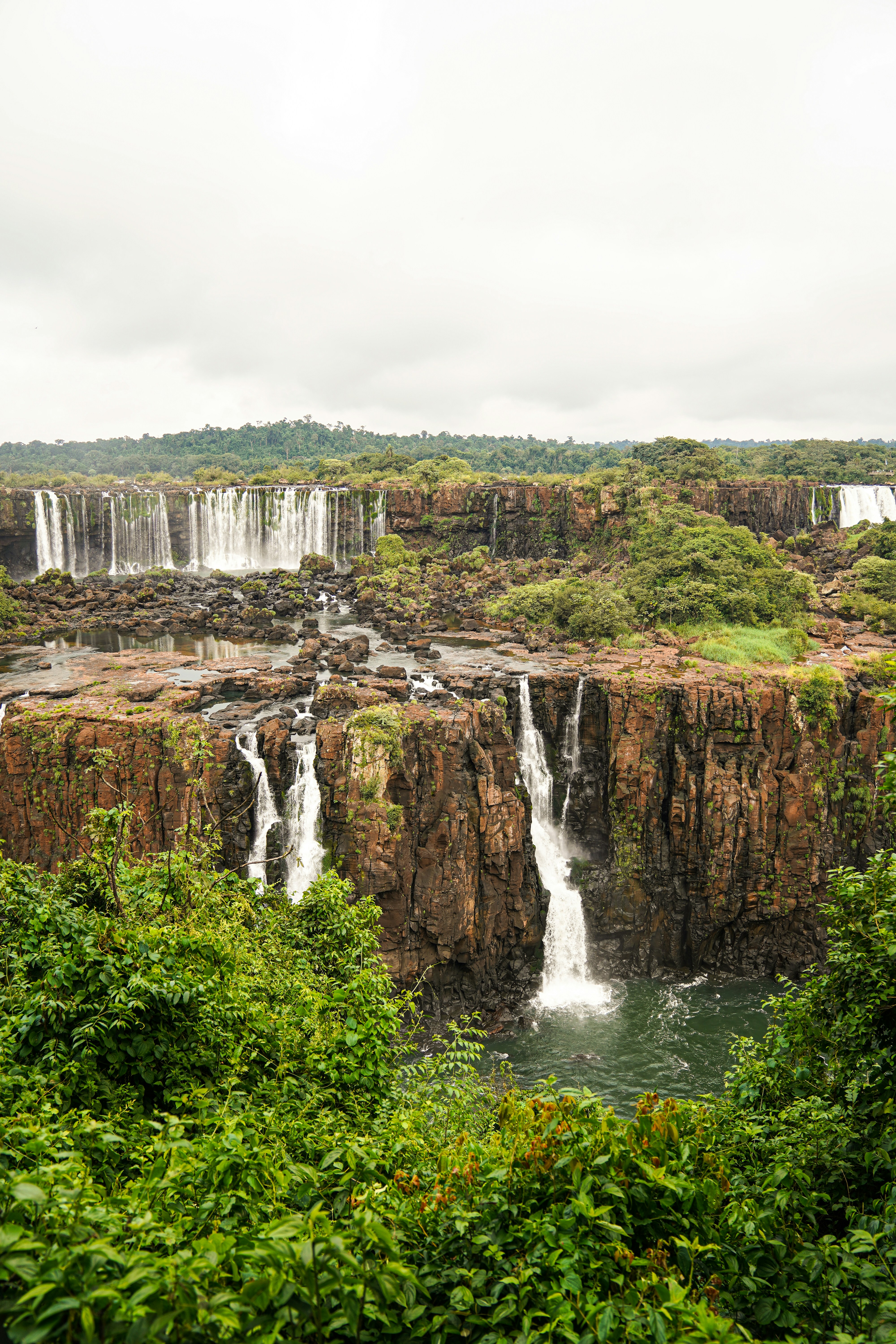 a large waterfall in the middle of a forest