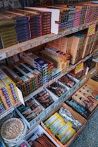 Shelves filled with a variety of incense products, each neatly packed in colorful boxes. The items are organized by brand and type, with price labels visible on the shelves. Decorative elements and promotional signs add to the inviting display.