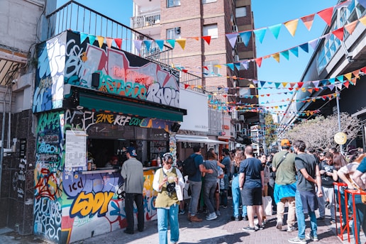 A vibrant street scene filled with diverse individuals engaging in lively conversations amidst colorful graffiti.