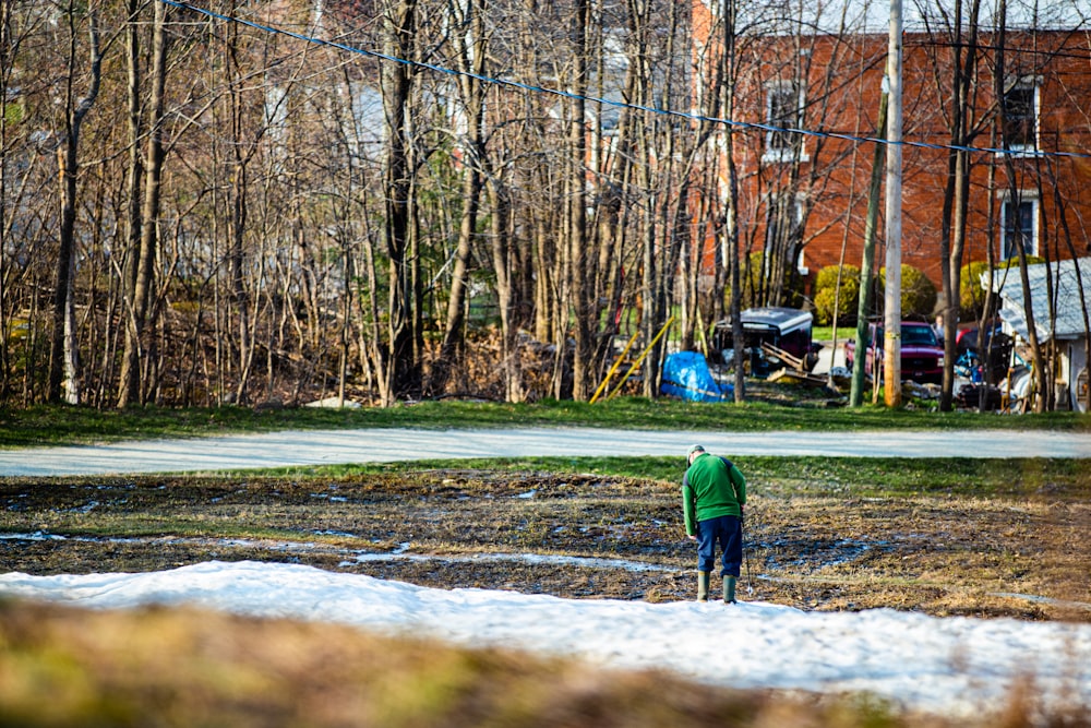 a person standing in a field with snow on the ground