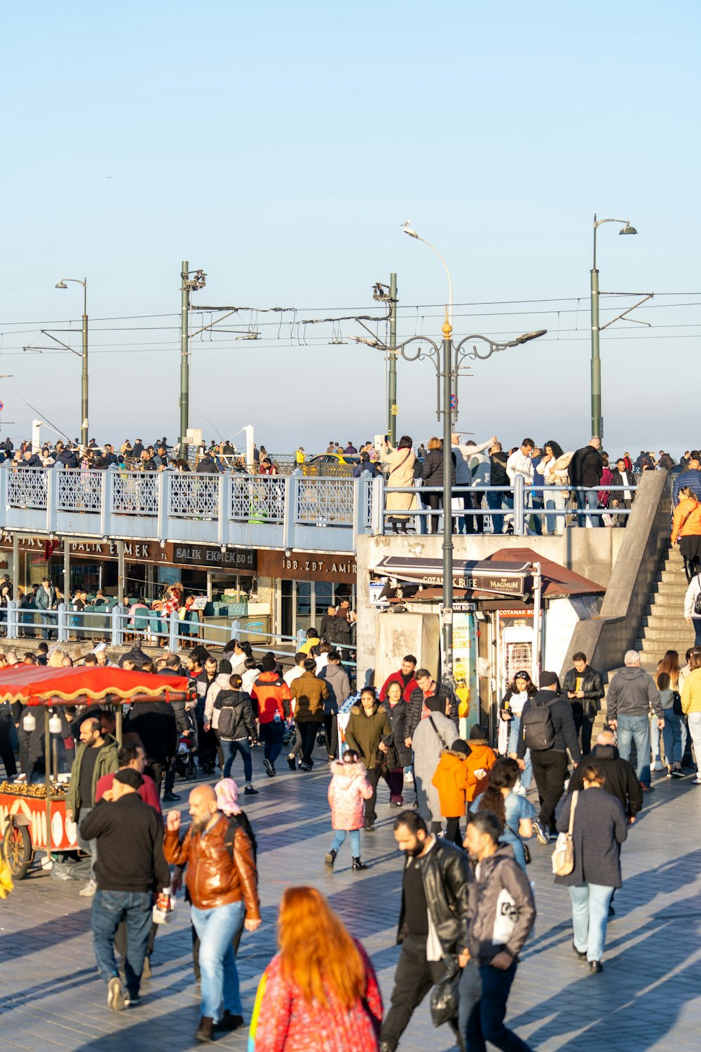 a crowd of people walking across a bridge