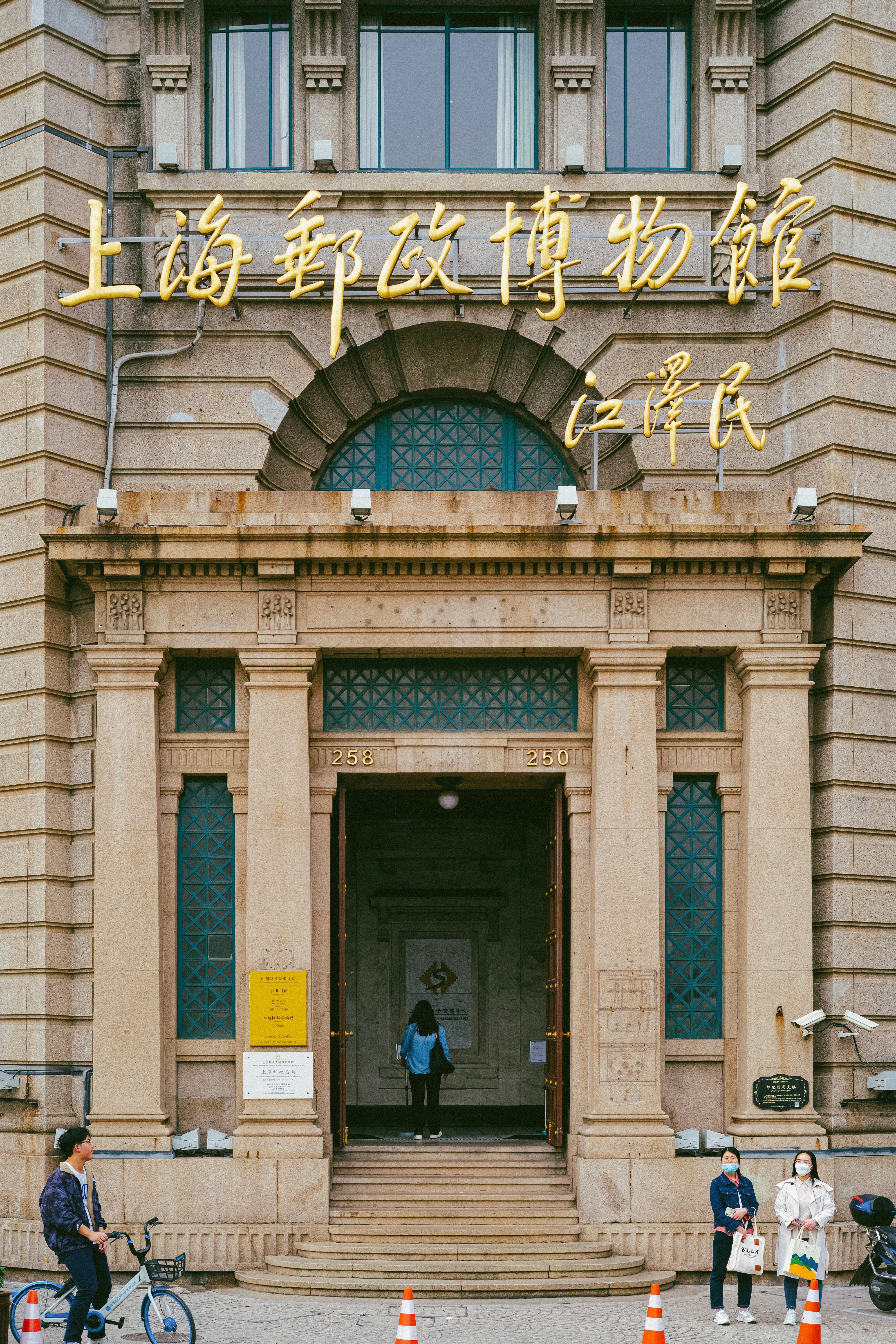 a man riding a bike past a tall building