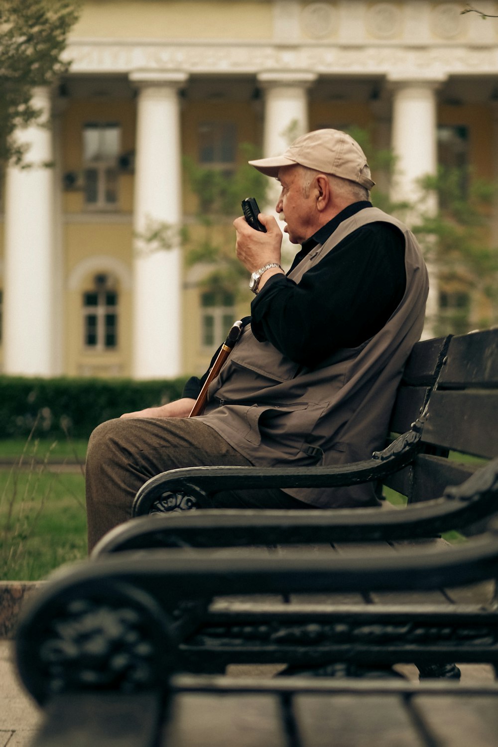 a man sitting on a bench with a cell phone in his hand