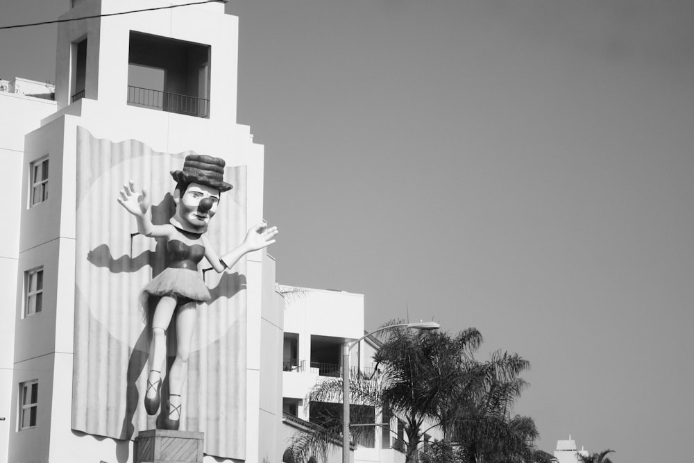 a black and white photo of a building with a giant statue of a man on