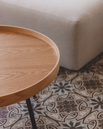 a wooden table sitting on top of a tiled floor