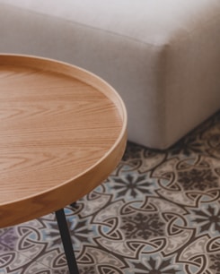 a wooden table sitting on top of a tiled floor