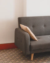 Detail of natural wood grain on sofa bed frame paired with turquoise accent pillows.