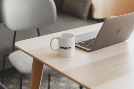 a white coffee mug sitting on top of a wooden table