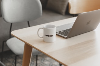 a white coffee mug sitting on top of a wooden table