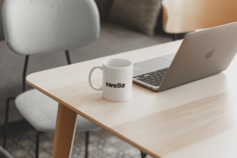 a white coffee mug sitting on top of a wooden table