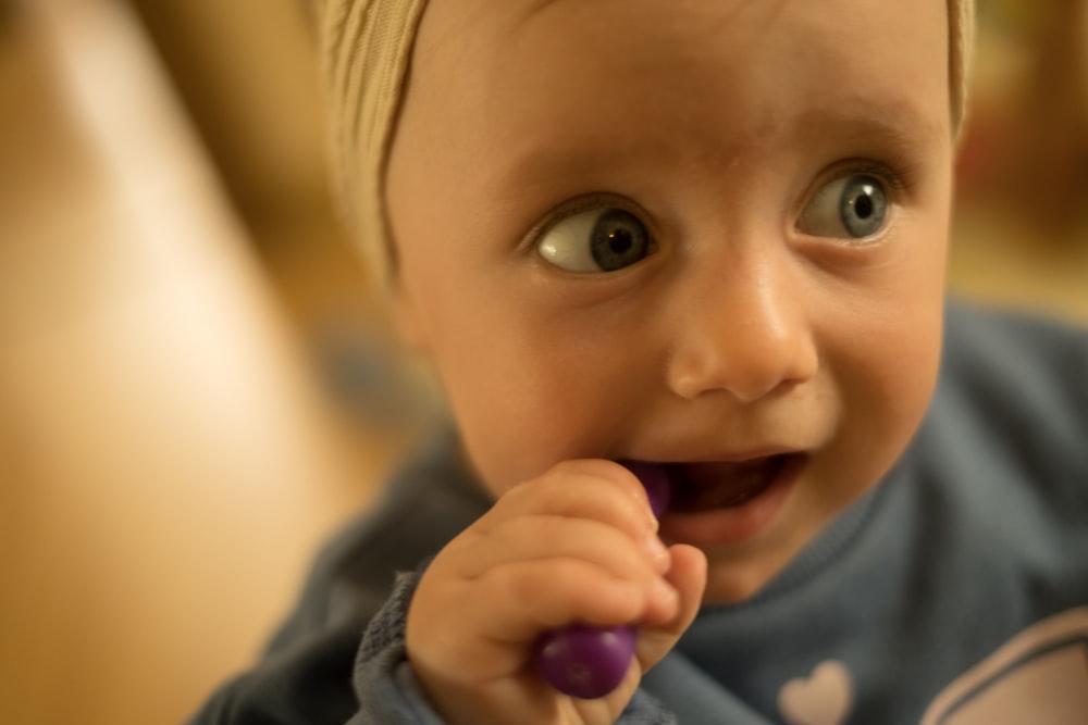 un bébé avec une brosse à dents dans la bouche