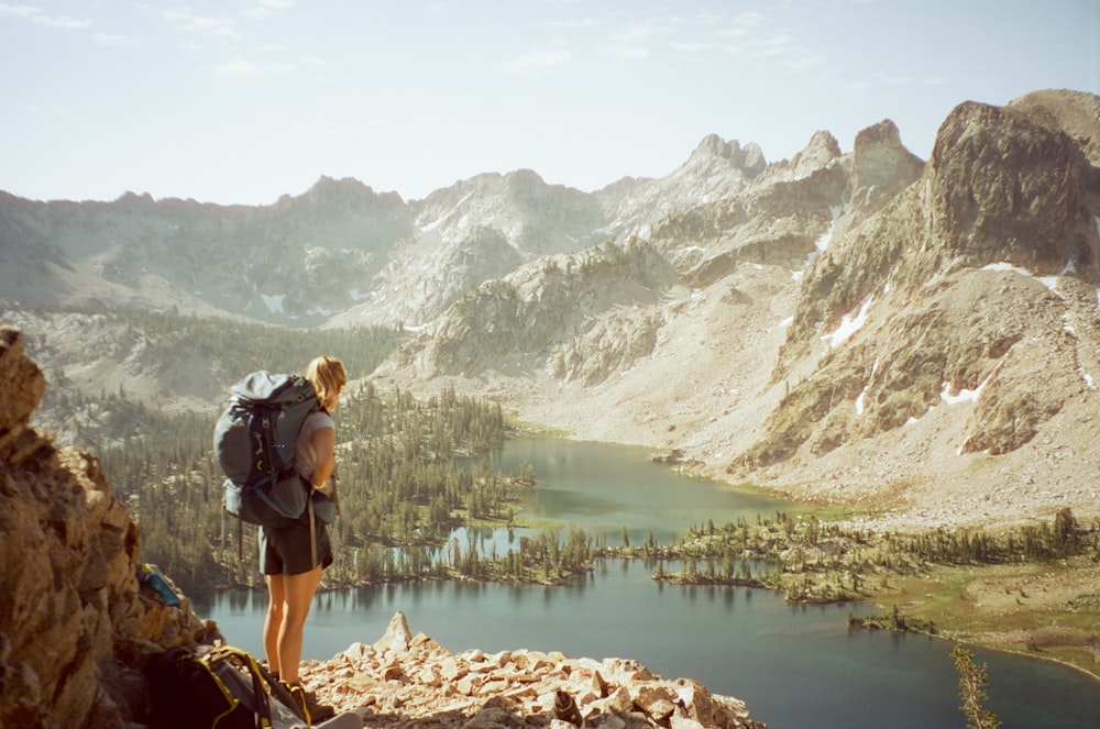 a person with a backpack standing on top of a mountain