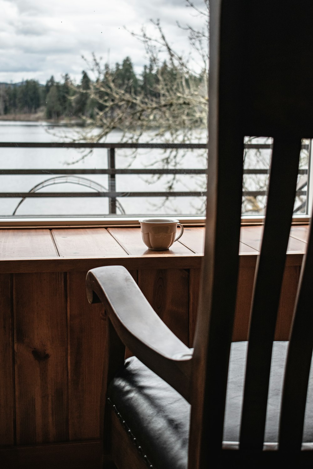 a wooden chair sitting on top of a wooden floor next to a window