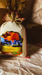 A rustic sack spilling organic mustard cake pellets onto a natural fiber cloth with green leaves nearby.
