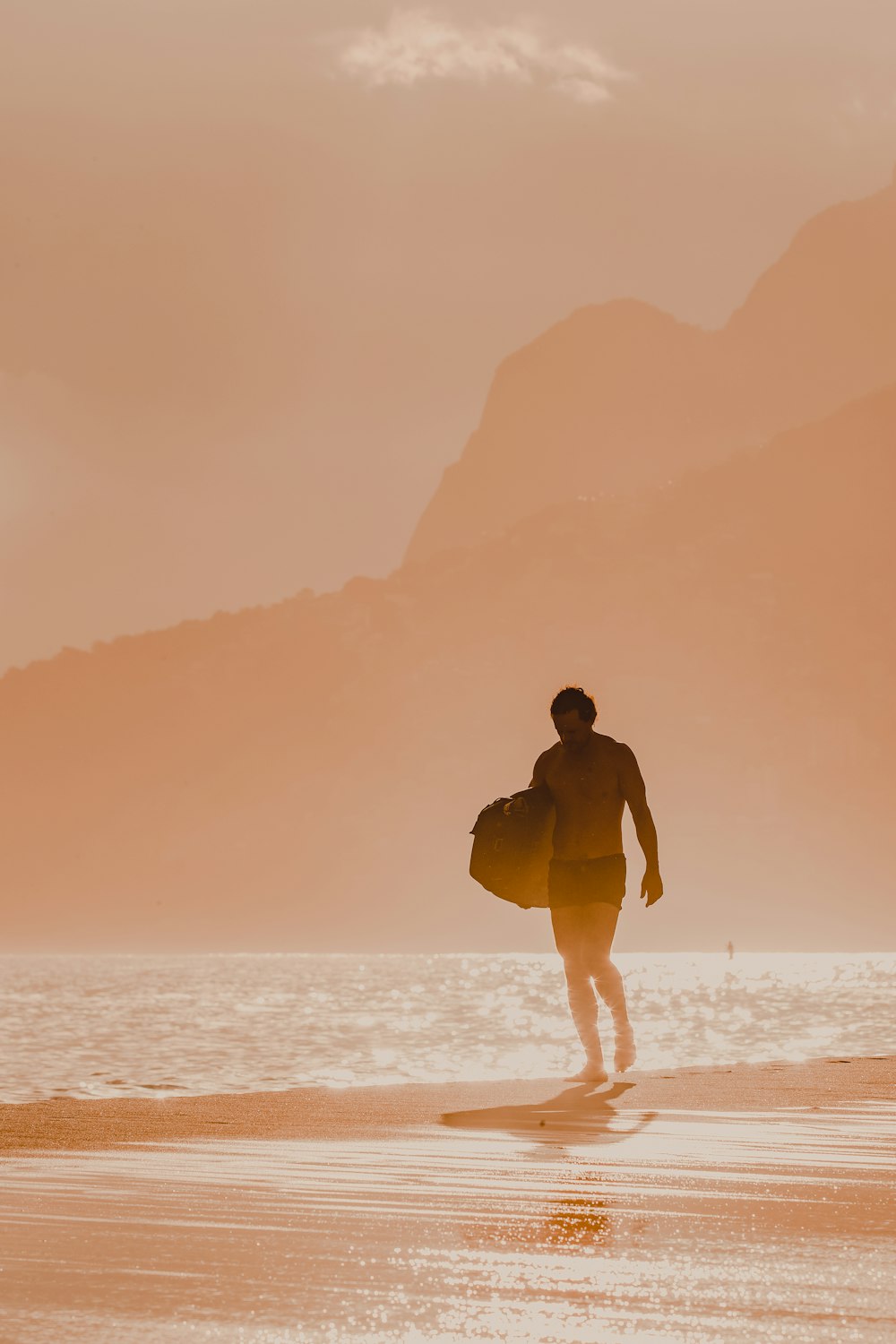 um homem com uma prancha de surf andando na praia