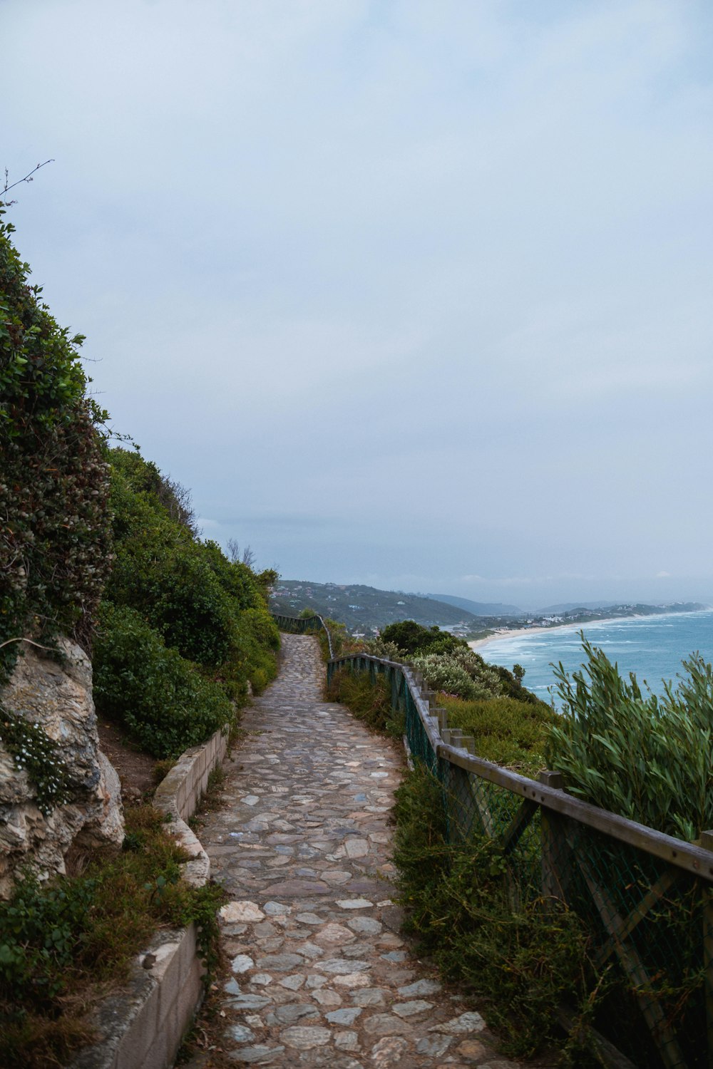 Un sentiero di pietra che porta all'oceano in una giornata nuvolosa