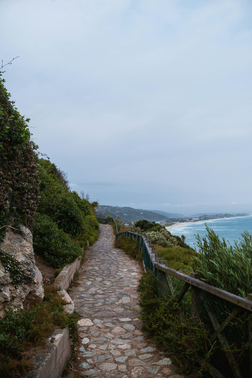 um caminho de pedra que leva ao oceano em um dia nublado