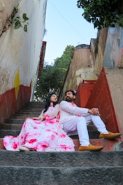 a man and a woman sitting on the steps of a building