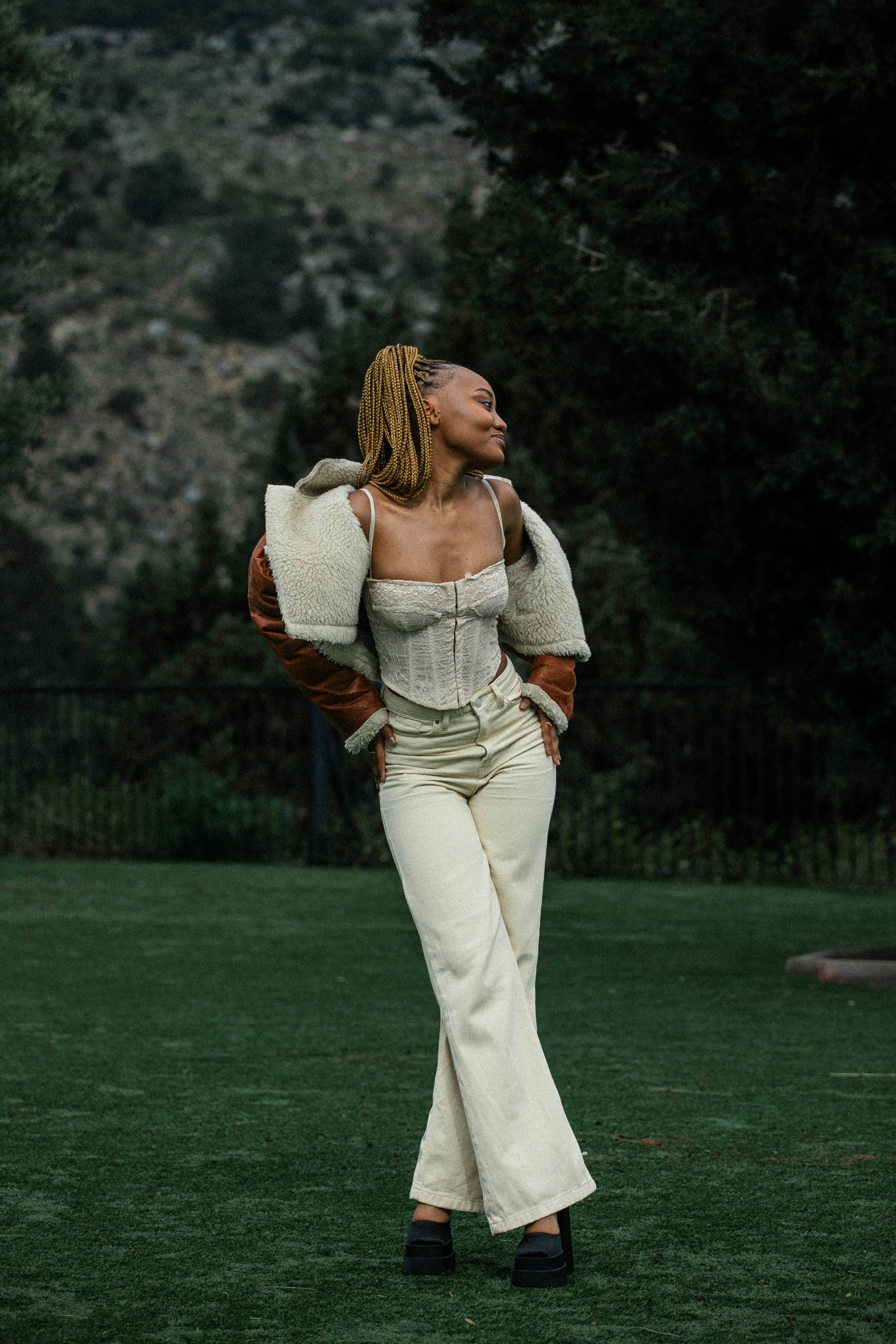 カメラに背を向けて草の中に立つ女性