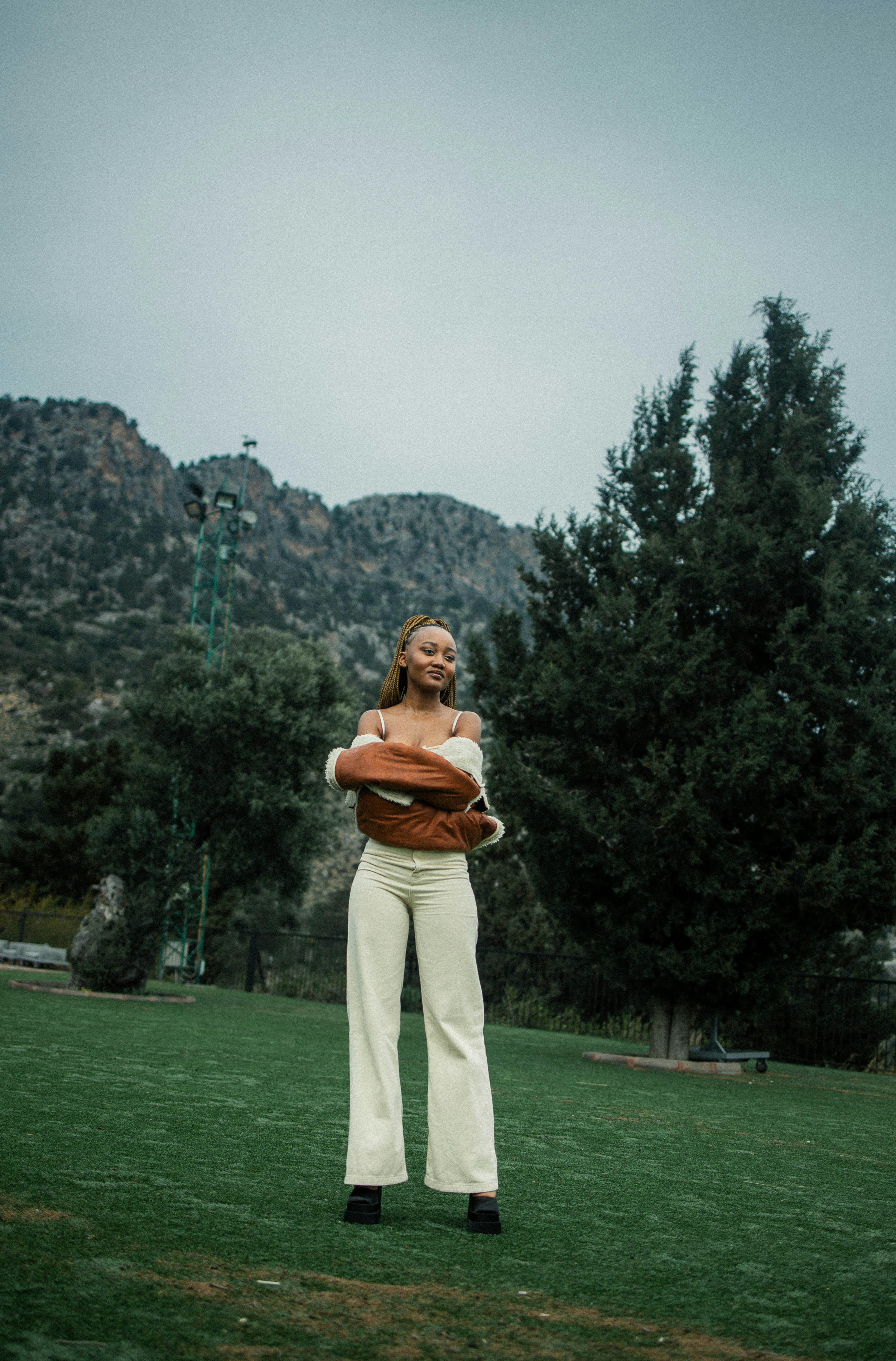 a woman standing in a field holding a baseball glove