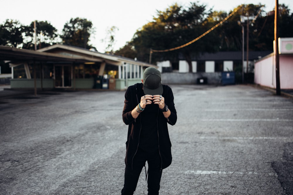 a man standing in a parking lot holding a camera