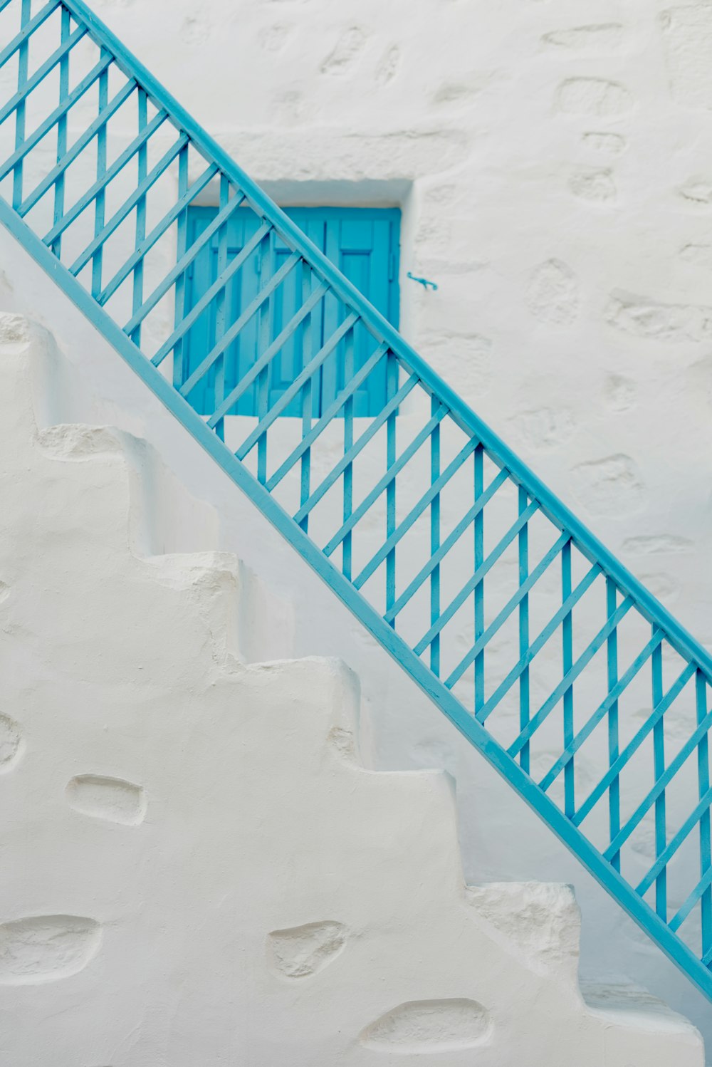 a blue and white staircase leading up to a blue door
