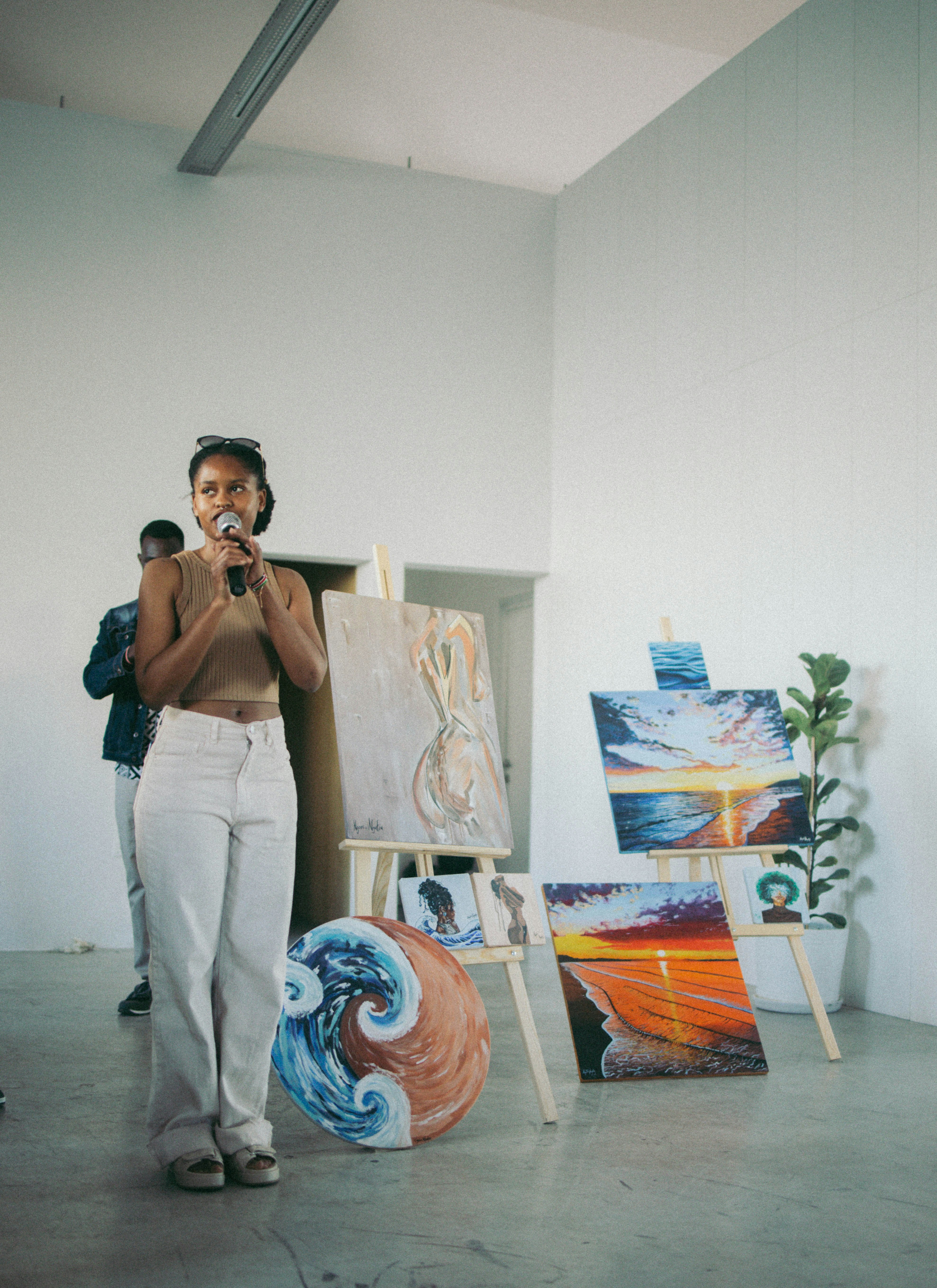 a woman standing in front of some paintings