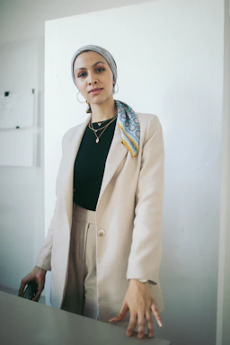 Close-up of a stylish woman’s outfit featuring a chic top and tailored pants, captured in natural light with a simple, elegant backdrop.