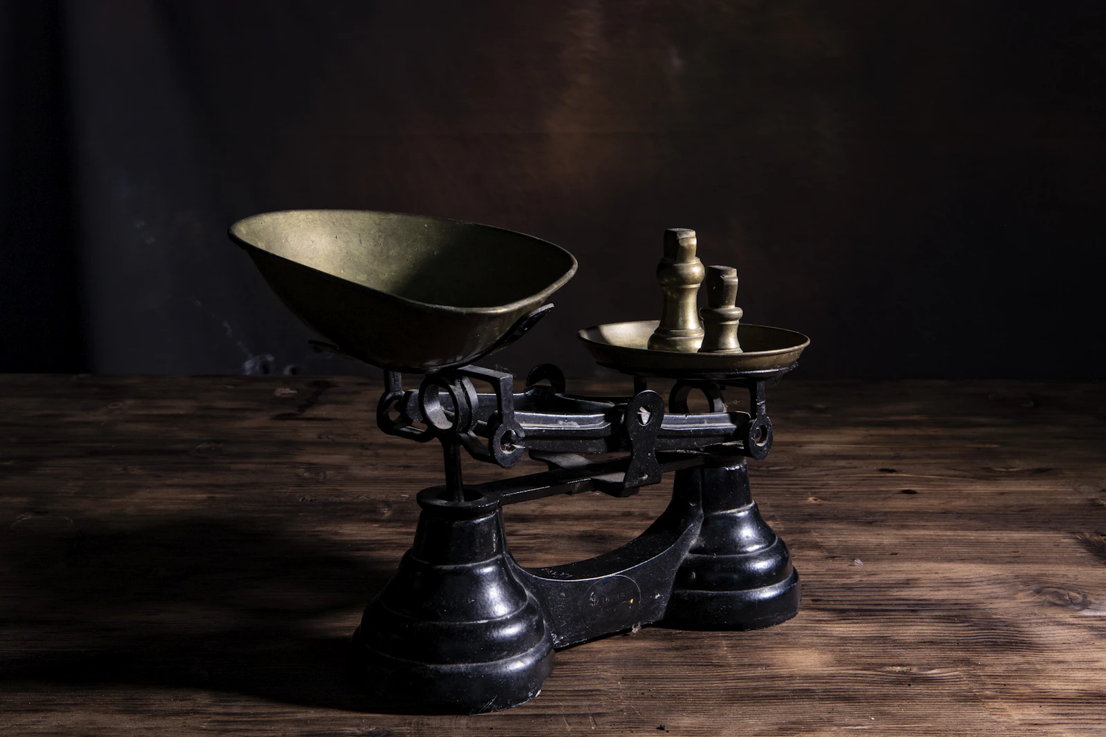 A brass balance scale, representing the weighing of what's actually verified in AEO/GEO advice against what's still genuinely unsettled