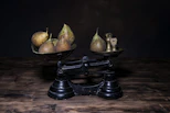 a couple of metal bowls filled with fruit on top of a wooden table