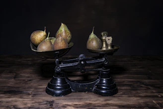 a couple of metal bowls filled with fruit on top of a wooden table