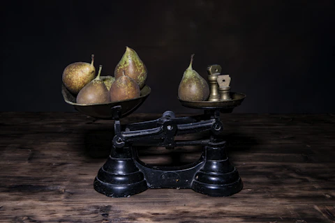 a couple of metal bowls filled with fruit on top of a wooden table