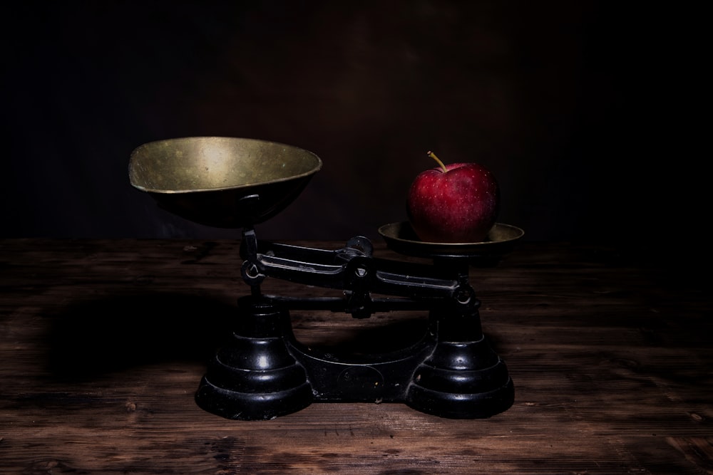 a red apple sitting on top of a scale