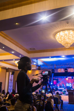 a woman standing in front of a camera in front of a crowd