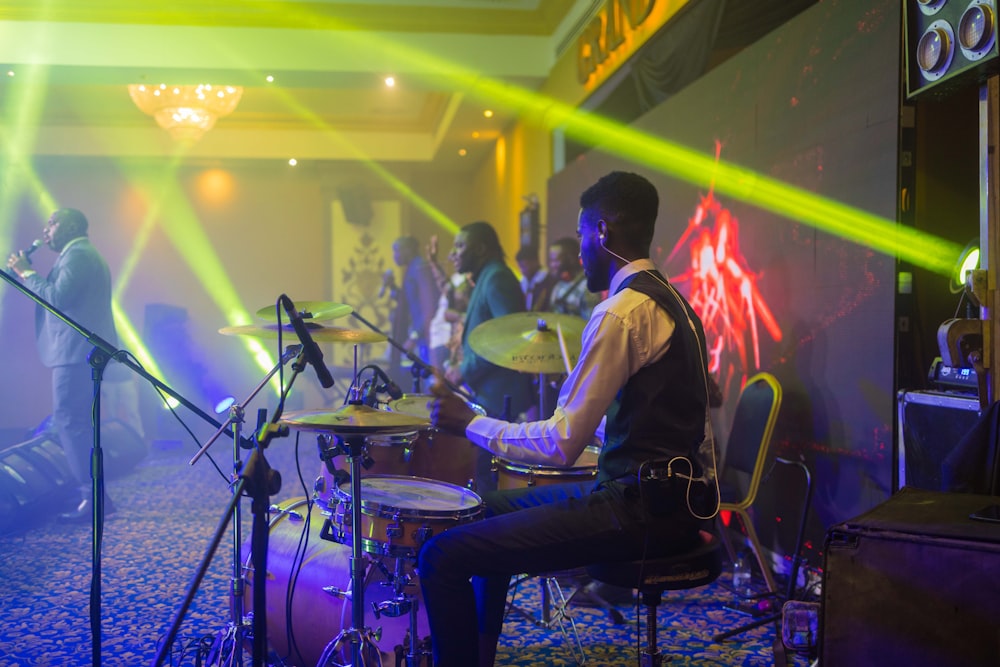 a man playing drums in front of a group of people