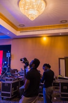 Team of videomakers setting up equipment at a vibrant party venue.