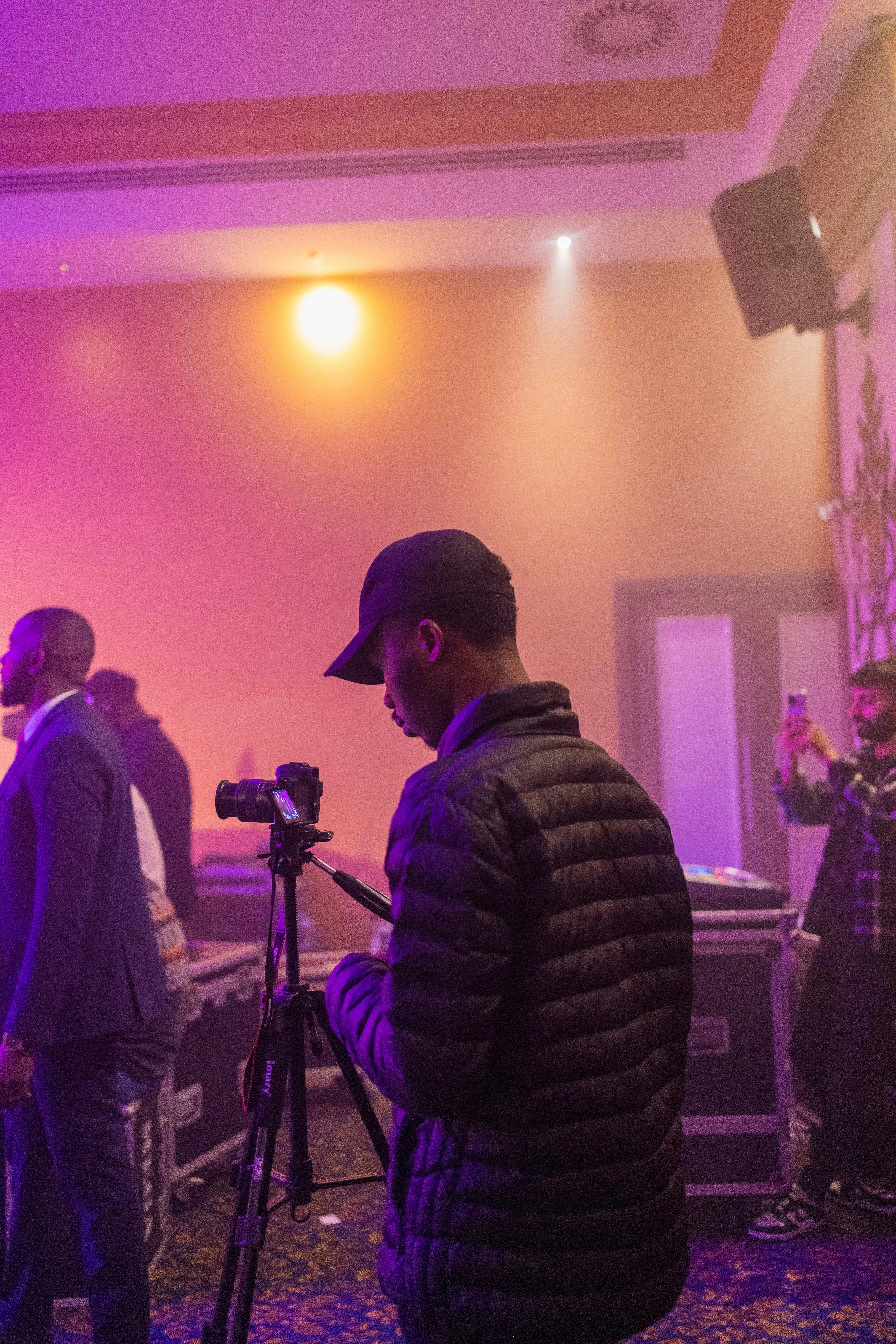 a man standing in front of a camera on a tripod