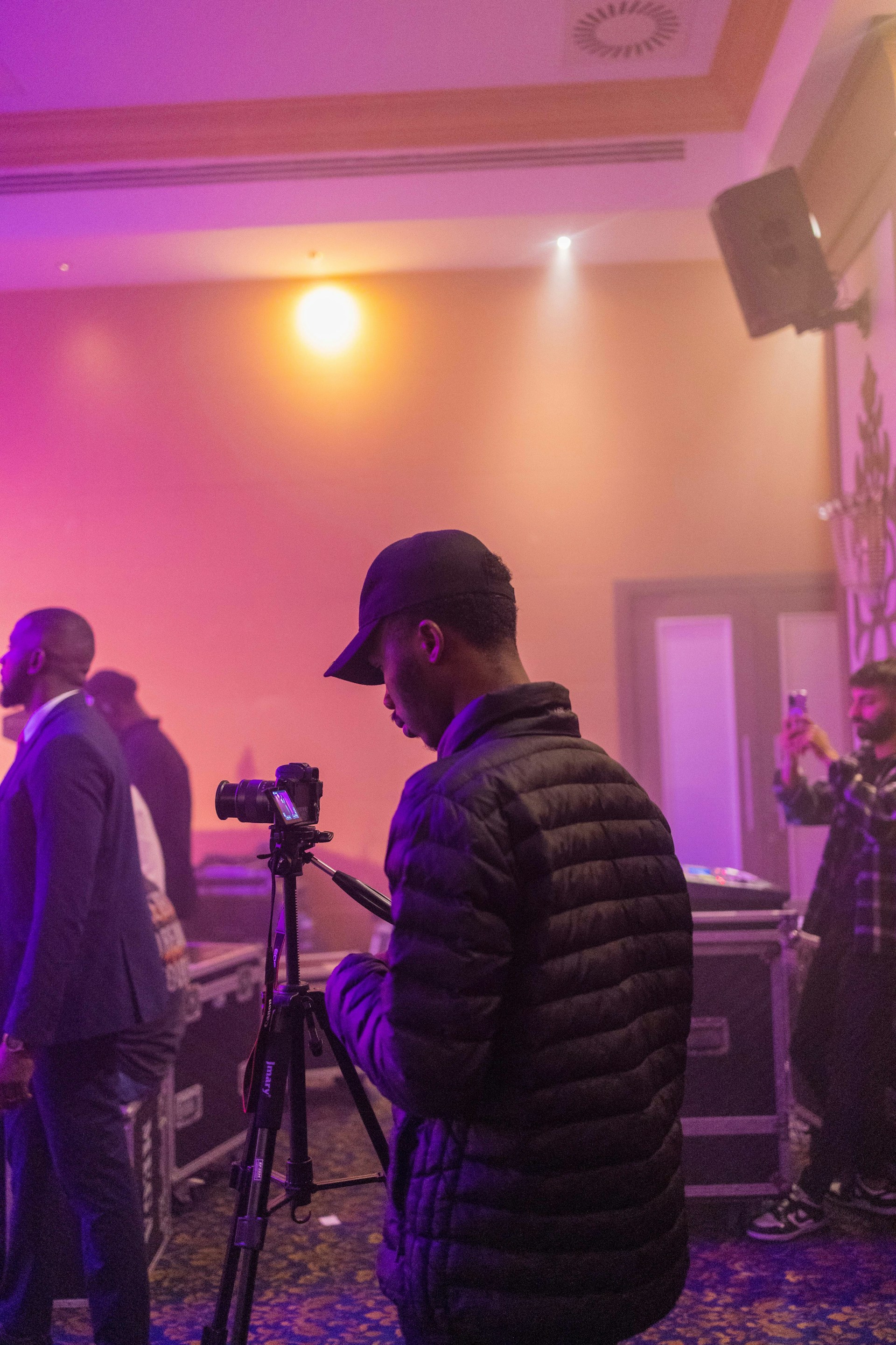 a man standing in front of a camera on a tripod