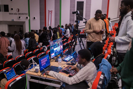 A vibrant newsroom with journalists working on computers and cameras capturing live reports.