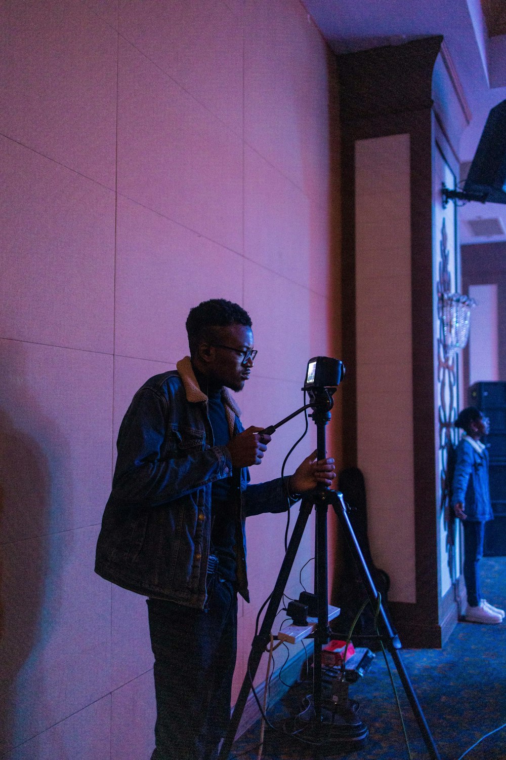 a man standing next to a camera on a tripod