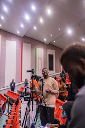 a man standing in front of a camera in a building