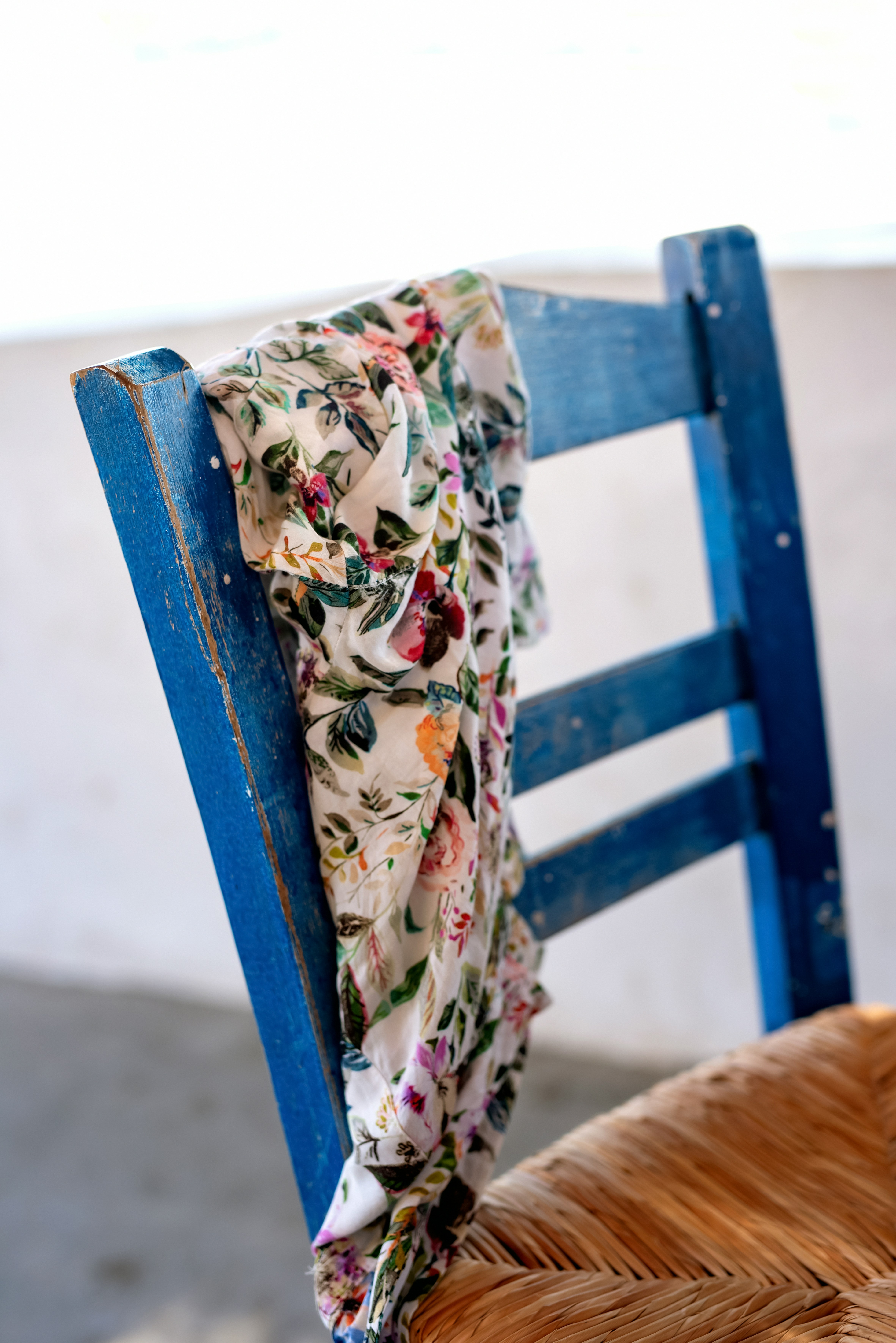 a blue chair with a flowered scarf on it