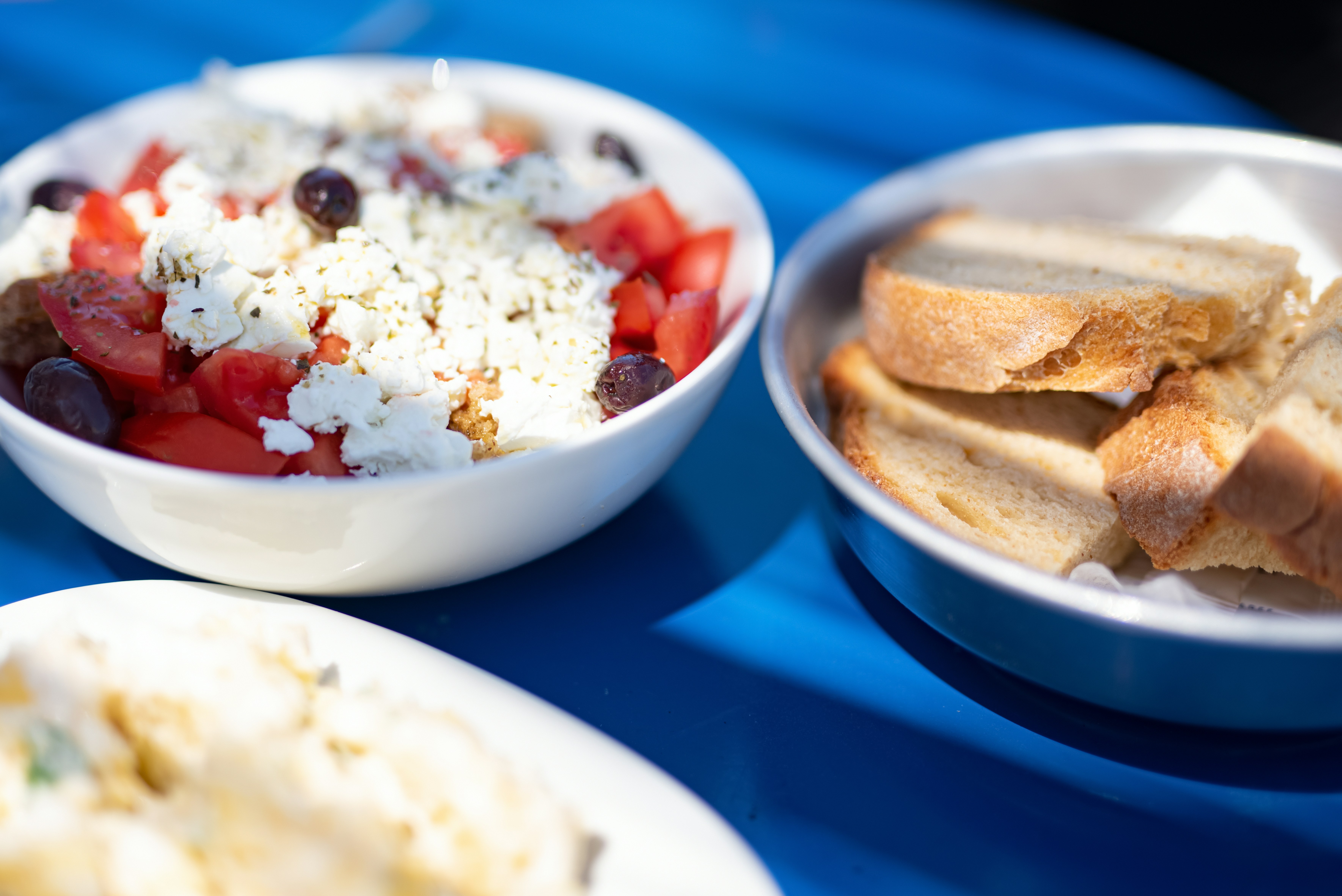 a blue table topped with bowls of food, 