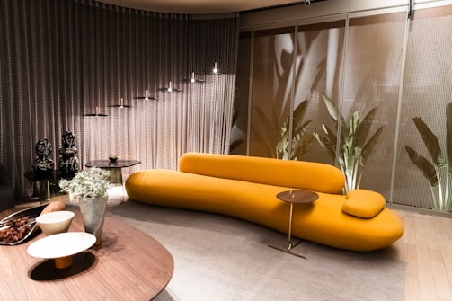 Interior shot of a modern living room with mustard yellow accents and metallic gray finishes.