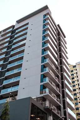 a tall building with many windows next to a street
