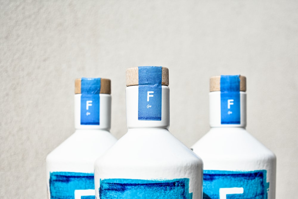 three white bottles with blue labels on them