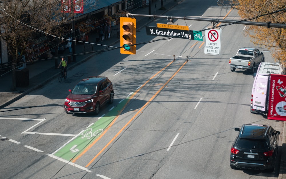 a red car driving down a street next to a traffic light