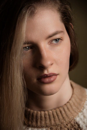 A close-up portrait of a model with natural makeup and soft lighting